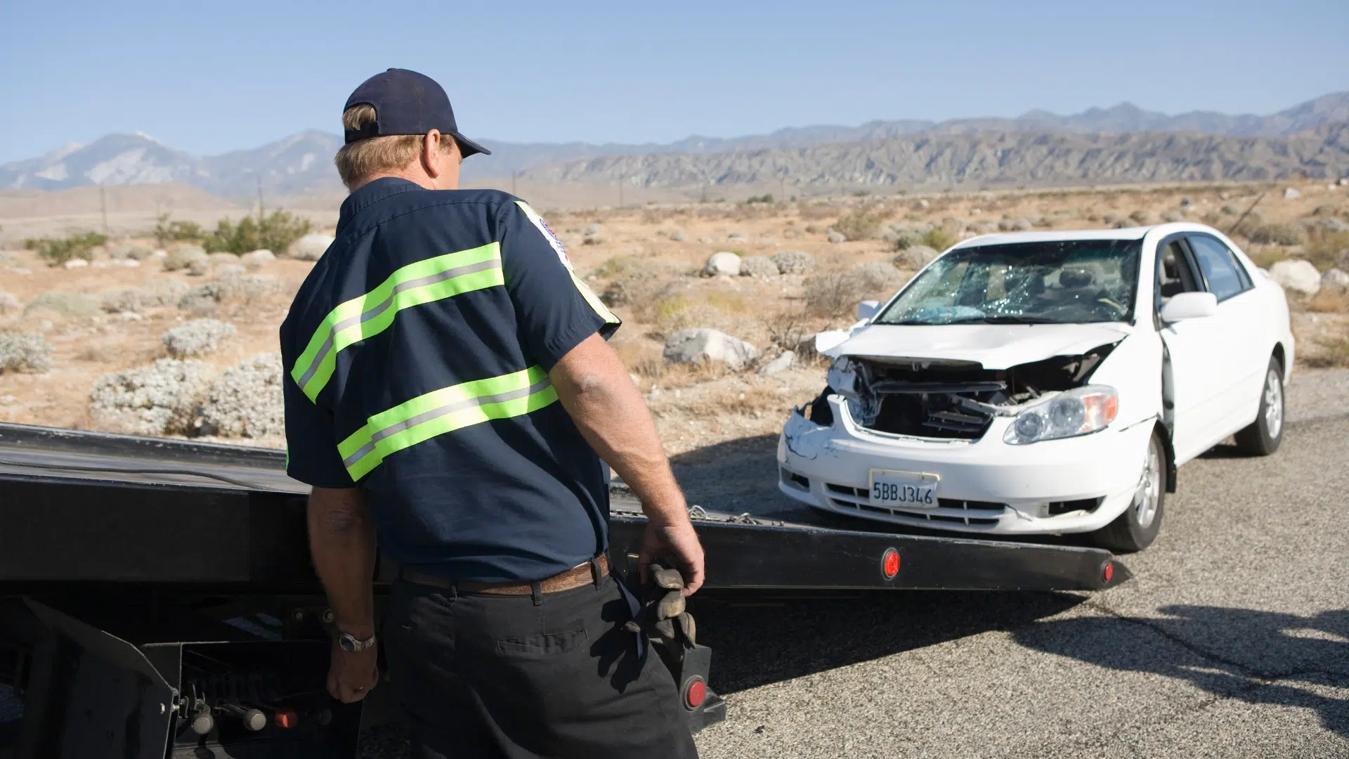 Tilt tray truck man recovering car